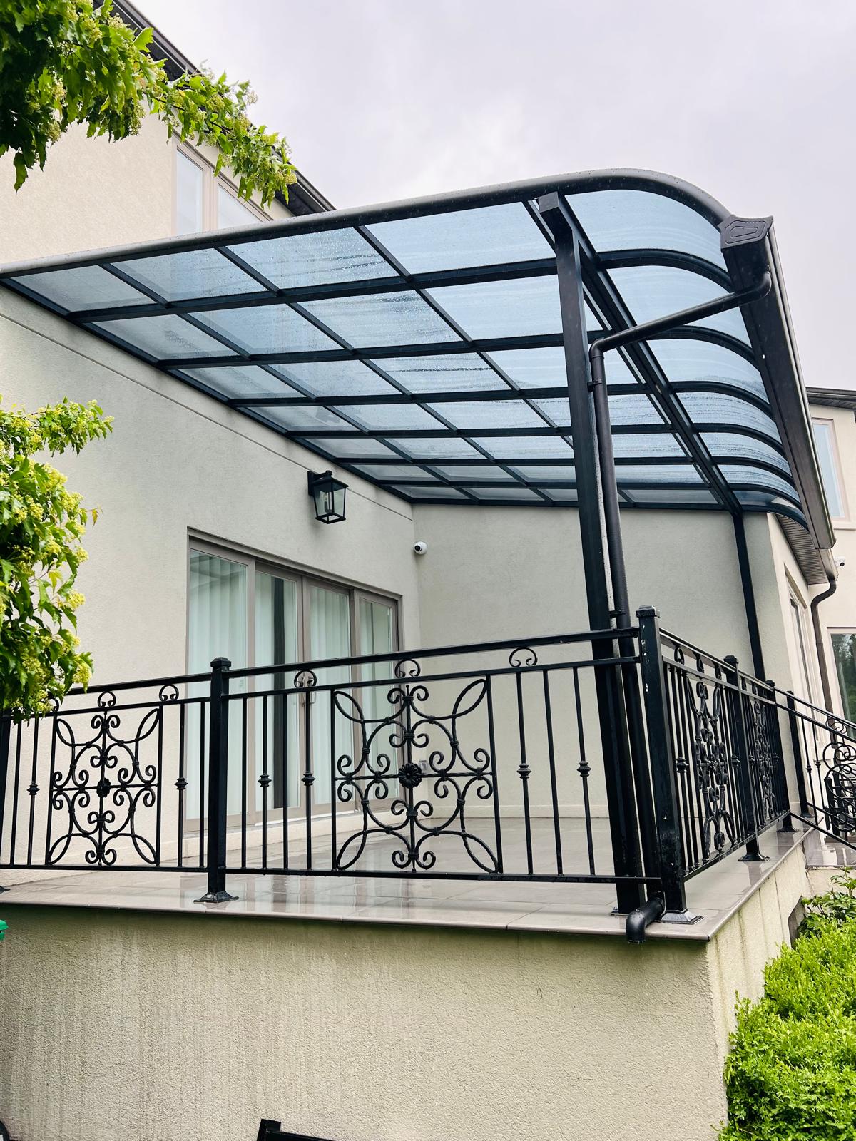Curved glass patio cover over a dining patio